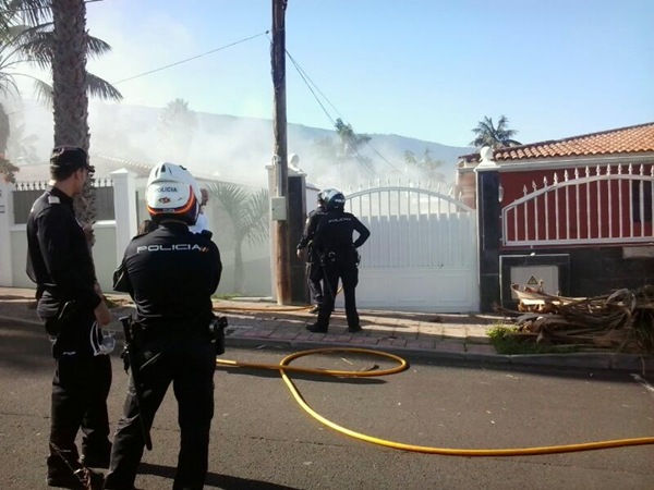 Bomberos y agentes de la Policía Nacional interviniendo en el incendio de la vivienda. | MOISÉS PÉREZ