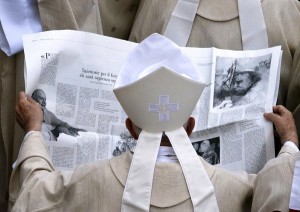 Un obispo mira un periódico local en el que se glosan las figuras de Juan XXIII y Juan Pablo II | REUTERS