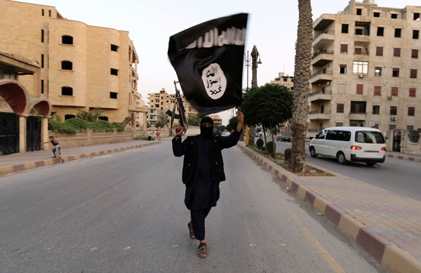 Un simpatizante del Estado Islámico de Irak y Siria ondea una bandera de este movimiento en Raqqa. / REUTERS