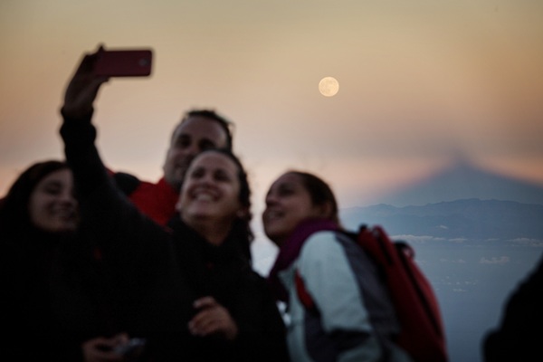 Un grupo de jóvenes, en el pico, con la superluna y la sombra del Teide al fondo. / A. G.