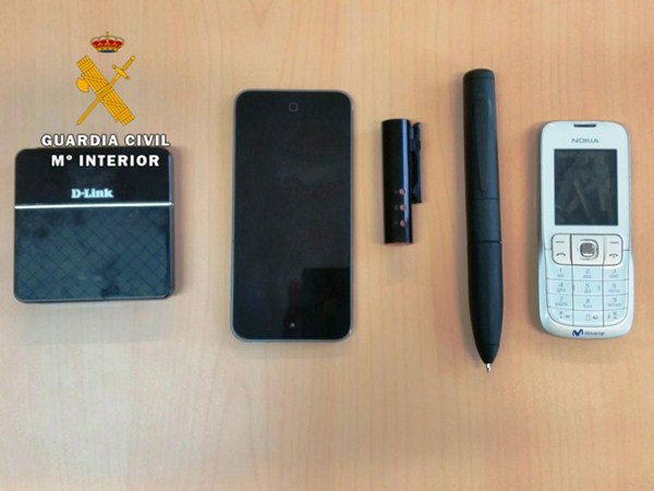 El 'kit de espía' estaba compuesto por una mini cámara, un dispositivo para captar la señal Wifi, un bolígrafo emisor y un teléfono móvil. / GUARDIA CIVIL