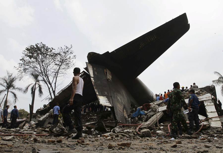 Security forces and rescue teams examine the the wreckage of an Indonesian military C-130 Hercules transport plane after it crashed into a residential area in the North Sumatra city of Medan, Indonesia