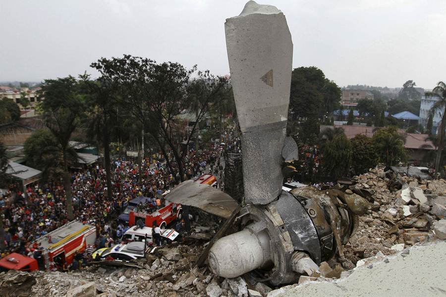 A propeller from an Indonesian military C-130 Hercules transport plane rests on the roof of a building after the plane crashed into a residential area in the North Sumatra city of Medan, Indonesia