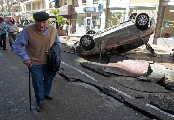 Un señor pasea entre los destrozos que han dejado las inundaciones. | REUTERS
