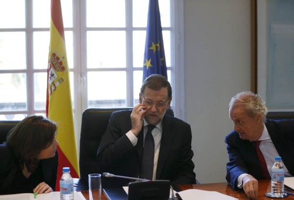 Mariano Rajoy habla con el ministro de Defensa Pedro Morenes  y la vicepresidenta Soraya Saenz de Santamaria al comienzo de la reunión del Consejo de Seguridad Nacional. | REUTERS