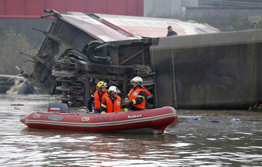 Rescue workers on a small boat search the wreckage of a test TGV train that derailed and crashed in a canal outside Eckwersheim near Strasbourg