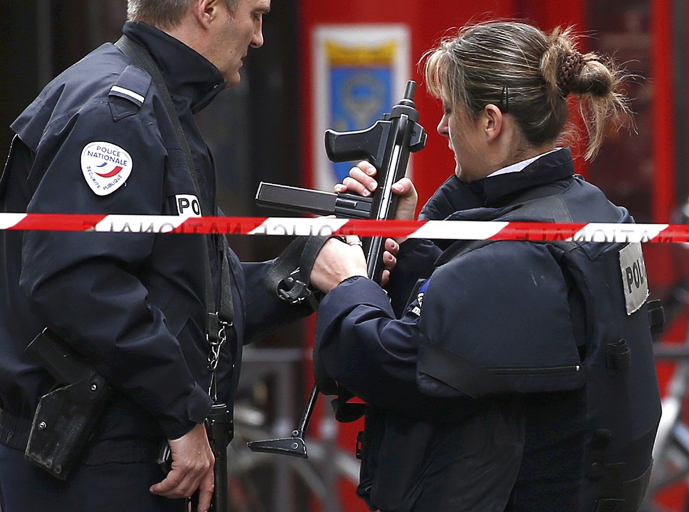Police officers stands guard at the scene of a shooting the day after a series of deadly attacks in Paris