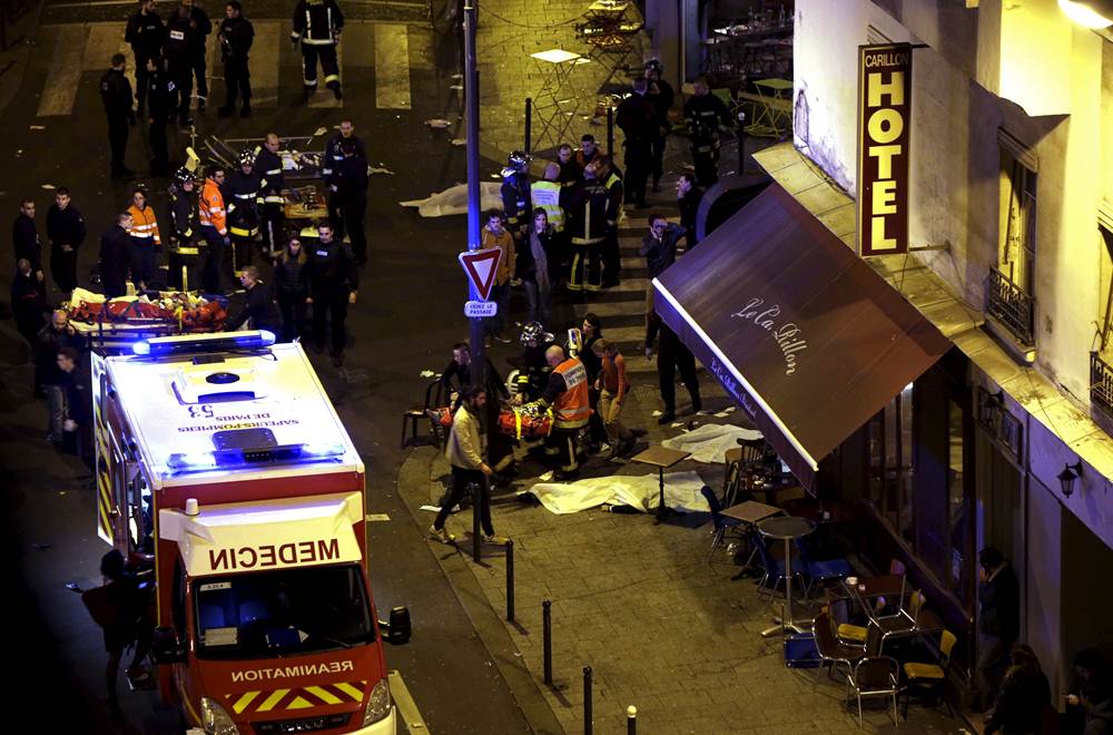 General view of the scene with rescue service personnel working near covered bodies outside a restaurant following shooting incidents in Paris, France