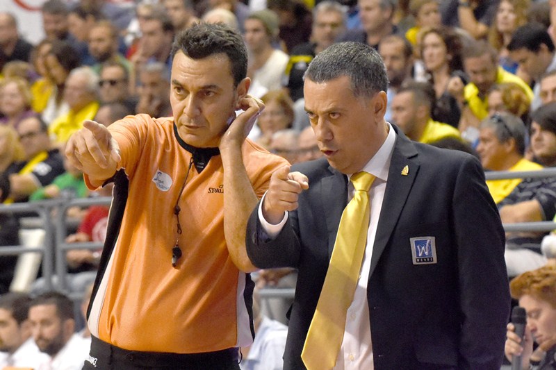 El entrenador del Iberostar Tenerife dialoga con uno de los colegiados durante el partido. / SERGIO MÉNDEZ