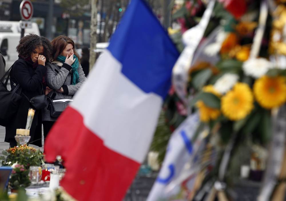 Two women cry as they pay tribute to the victims of Paris attacks at the Place de la Republique in Paris