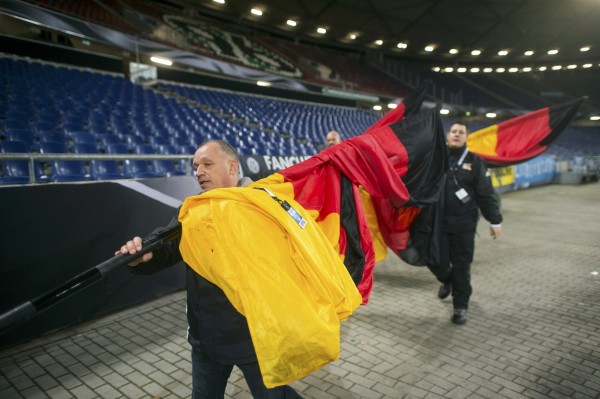 Operarios retiran las últimas banderas durante el desalojo del estadio de Hannover (Alemania). / REUTERS 