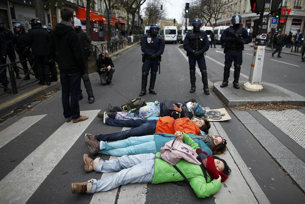 Environmentalists protest in front of French CRS riot police near the Place de la Republique after the cancellation of a planned climate march following shootings in the French capital, ahead of the World Climate Change Conference 2015 (COP21), in Paris