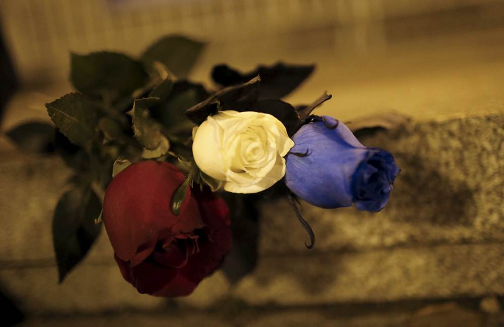 Blue, white and red roses, in the colors of the French flag, lie on the ground in tribute to the victims of Paris attacks in Tbilisi
