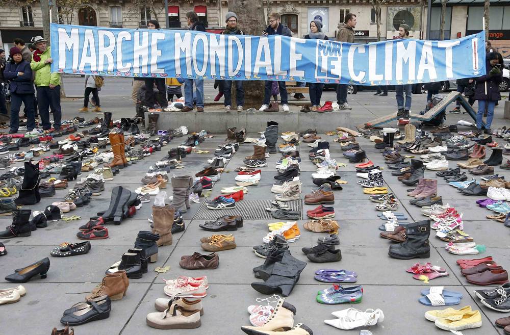 A banner which reads “Global Climate March” is displayed in front of pairs of shoes symbolically placed on the Place de la Republique ahead of the World Climate Change Conference 2015 in Paris