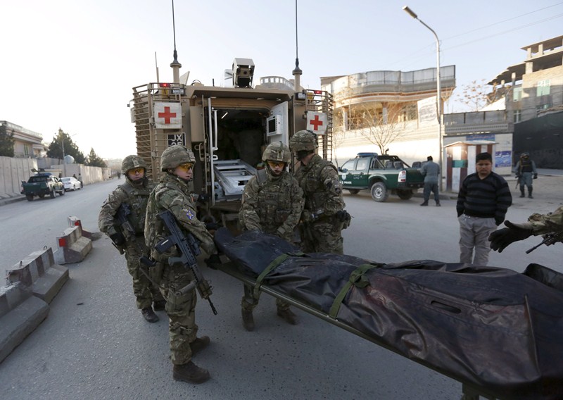 British soldiers carry the dead body of a victim after an attack on a guest house near the Spanish embassy in Kabul, Afghanistan