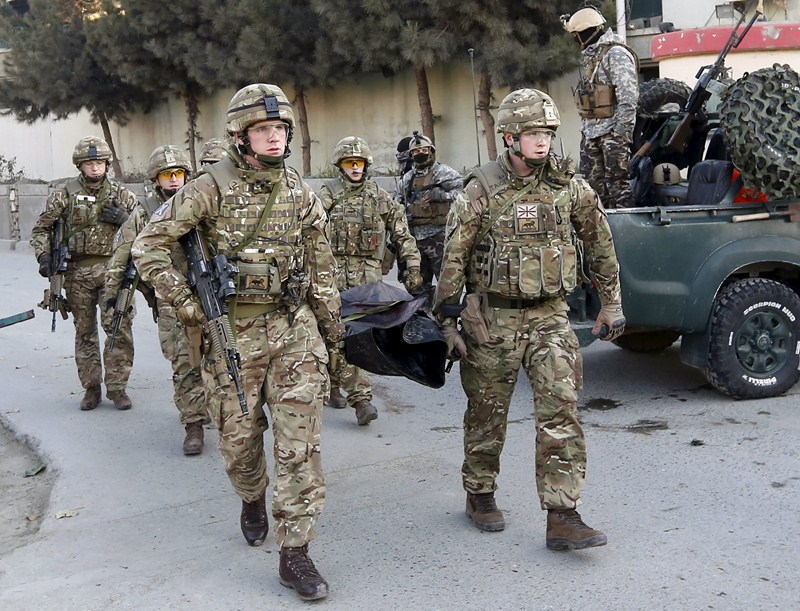 British soldiers carry the dead body of a victim after an attack on a guest house attached to the Spanish embassy in Kabul, Afghanistan