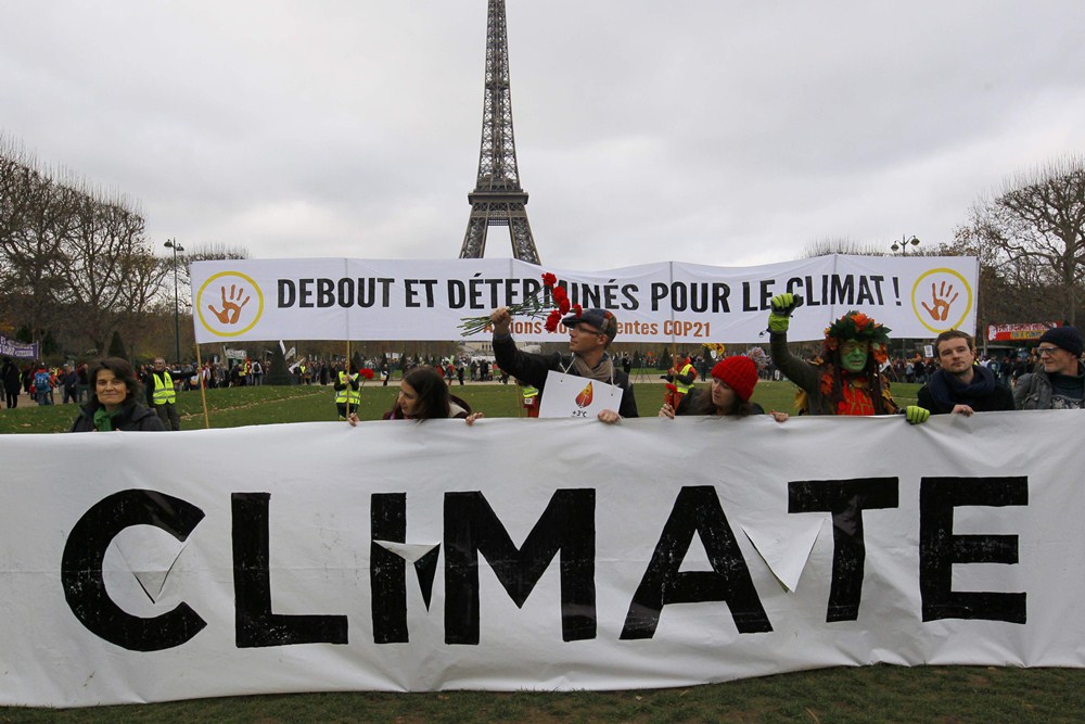 Environmentalists hold a banner which reads, ‘Standing and Determined for the Climate” at a protestdemonstrationnear the Eiffel Tower in Paris, France, as the World Climate Change Conference 2015 (COP21) continues near the French capital