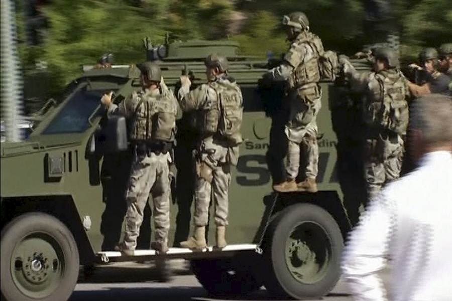 Still image from video shows Police SWAT team units on an armored vehicle arriving outside the Inland Regional Center in San Bernardino