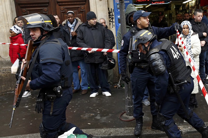 French police secure the area after a man was shot dead outside a police station in the 18th district in Paris