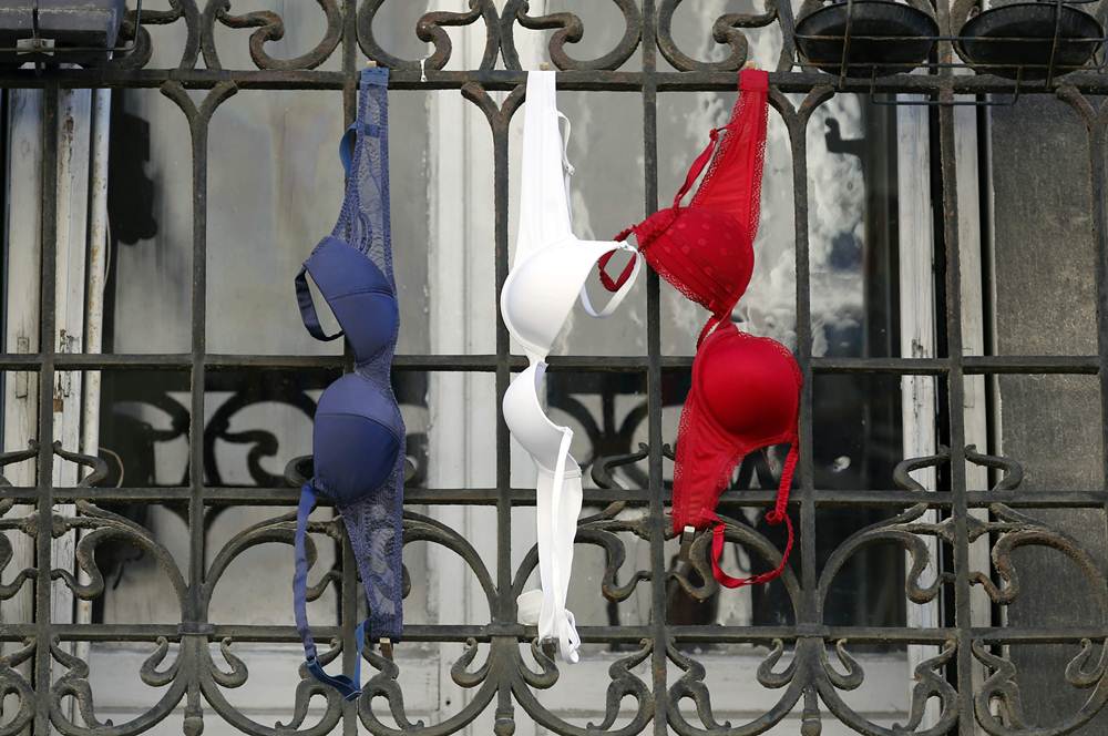 Blue, white and red brassieres, the colours of the French national flag, hang from a balcony in Marseille